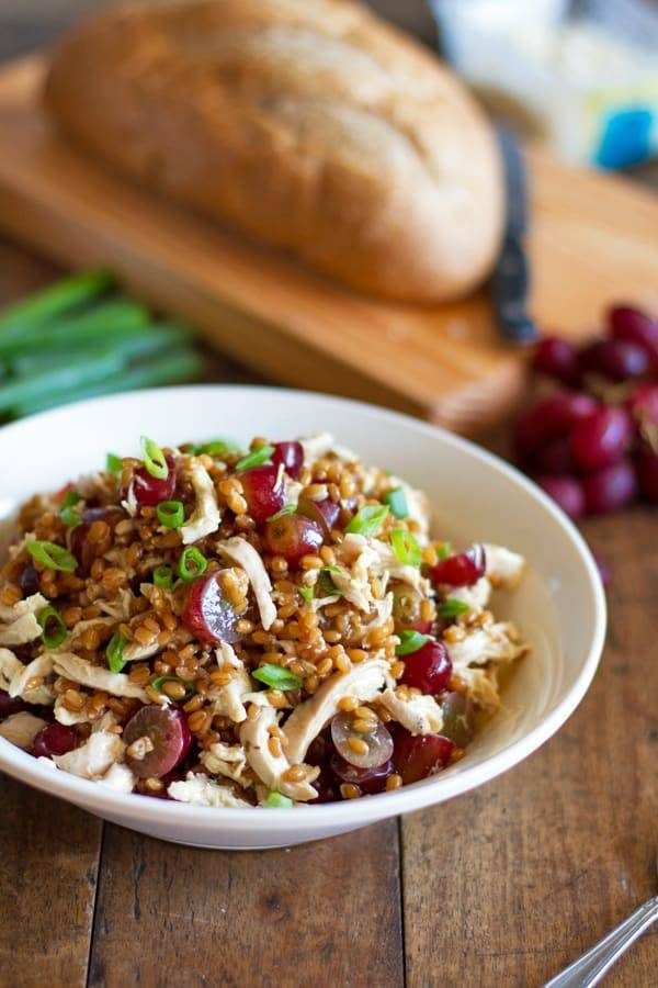 Bowl of honey chicken salad with grapes and feta.